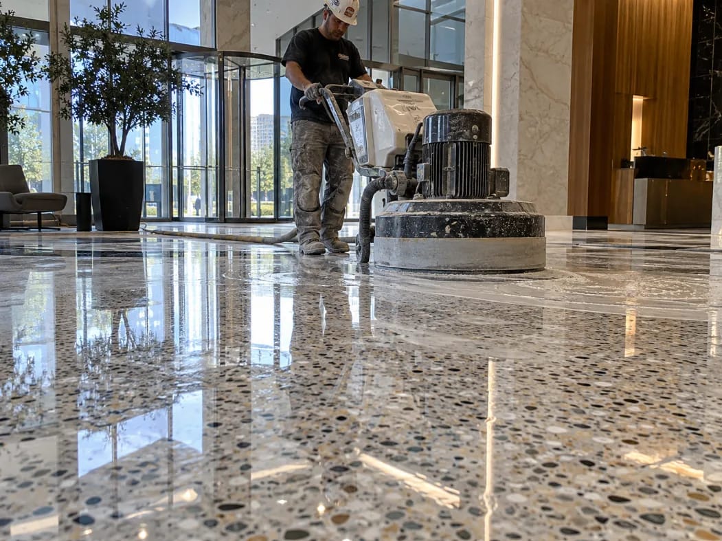 Terrazzo floor polishing with a diamond grinder in a commercial lobby, restoring a high-gloss finish