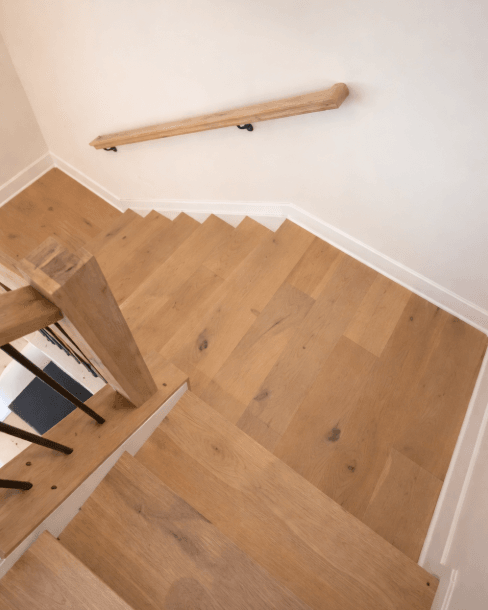 Custom white oak hardwood landing and stair trim installed by 2020 Flooring in a Montgomery County home