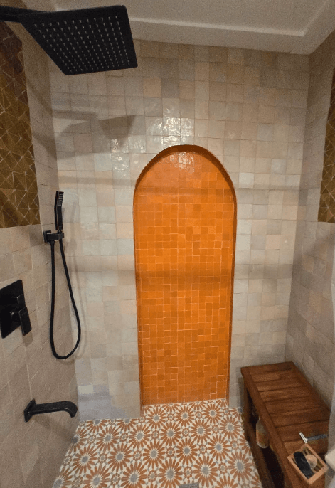 Walk-in shower with black fixtures and custom tile accents in Potomac MD