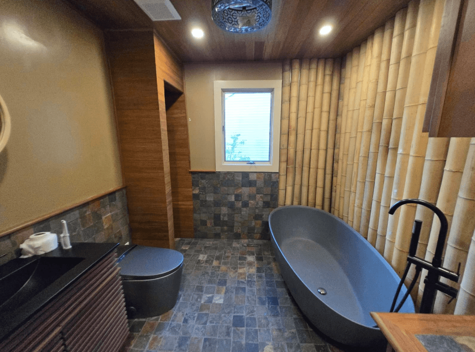 Freestanding tub with bamboo wall and black faucet in Fulton MD