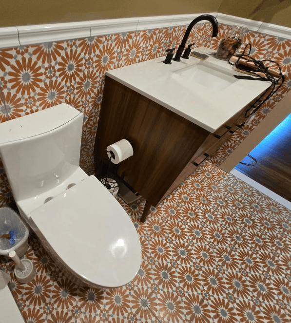 Bathroom with patterned tile floor, wood vanity, and modern sink in Potomac MD