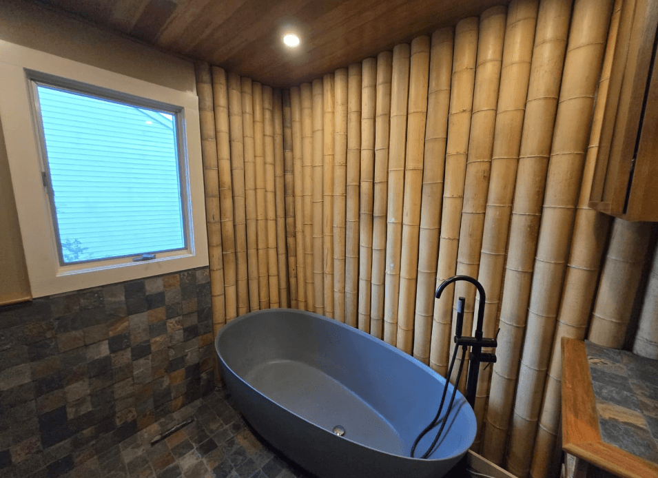 Bathroom with stone tile floor and freestanding tub with black fixtures in Fulton MD
