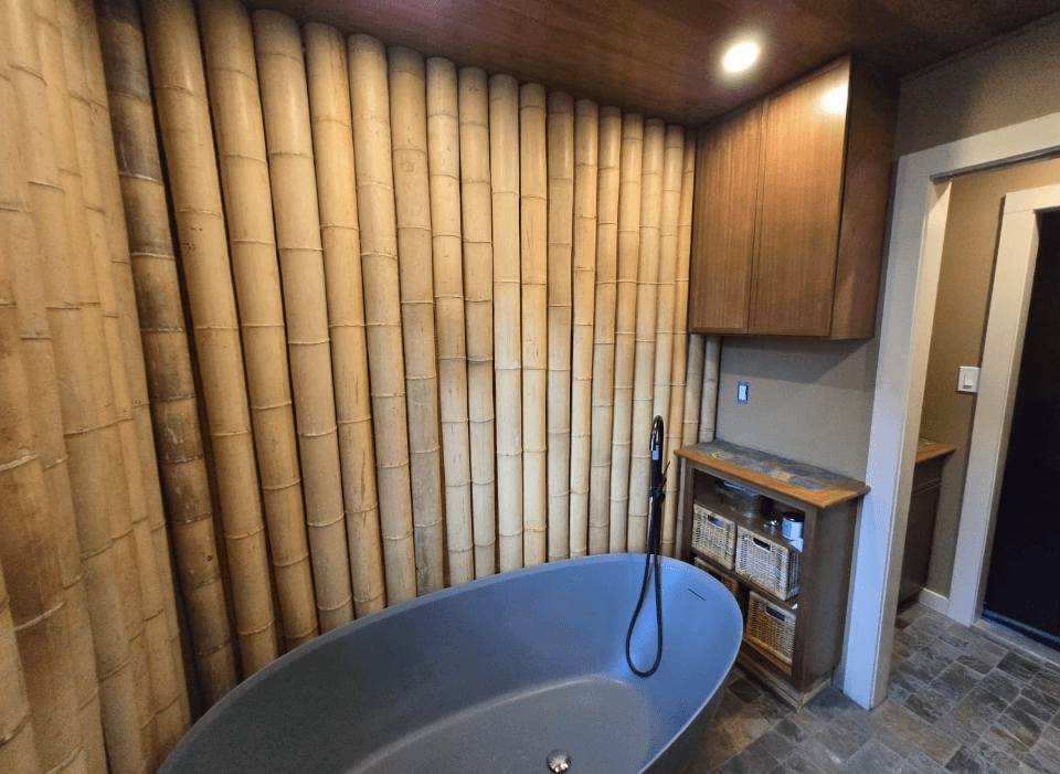 Bathroom with bamboo accent wall, freestanding tub, and stone tile floor in Columbia MD